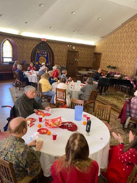 Guests gather around tables for lunch and conversation.